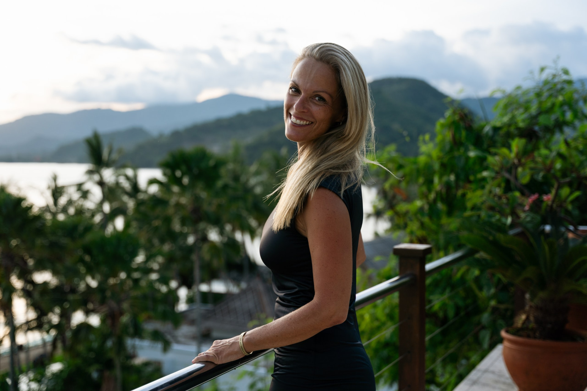 Marie Zollet souriante sur une terrasse face aux montagnes au coucher du soleil